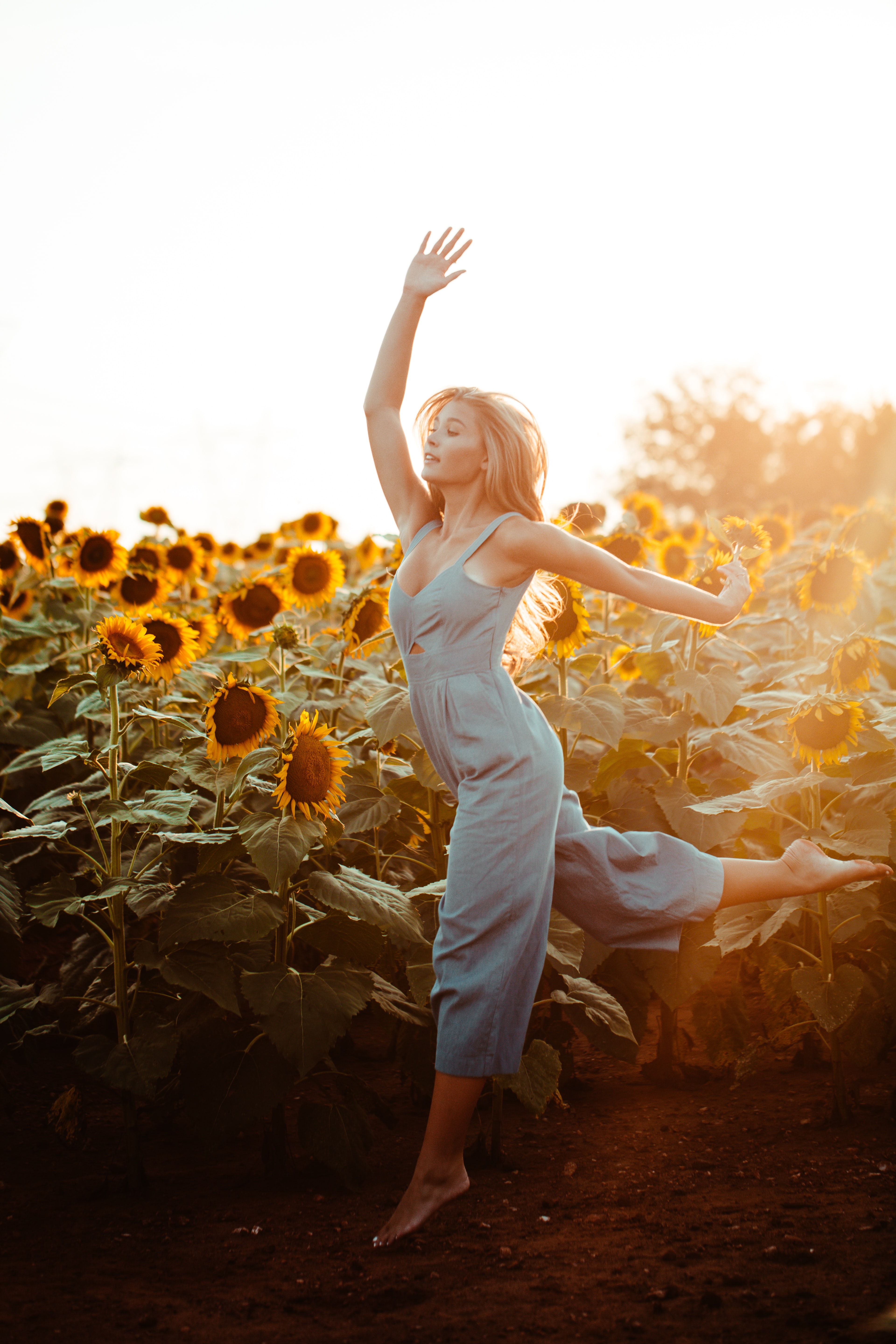 Women dancing in sunflower field