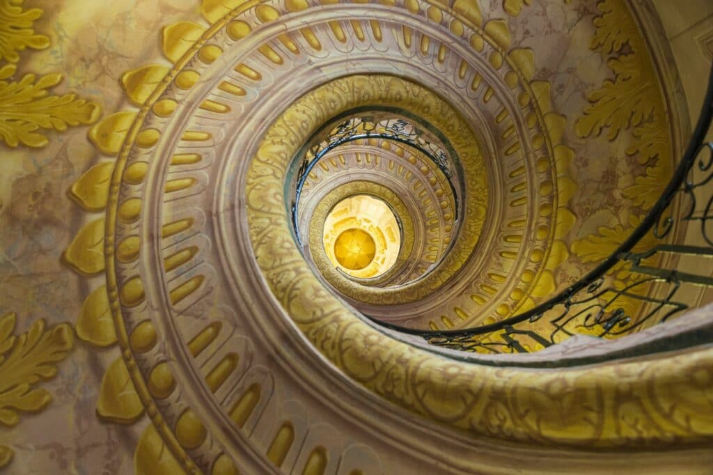 Low angle view of spiral staircase decorated with murals of golden Acanthus flowers and ornamental